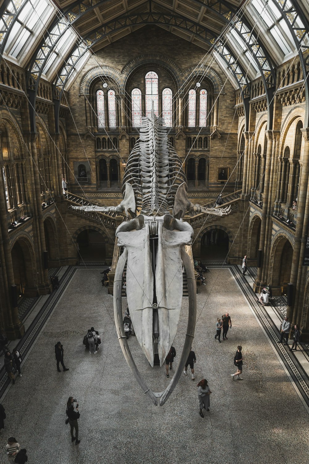 a large stone building with a large statue in the middle with Natural History Museum in the background