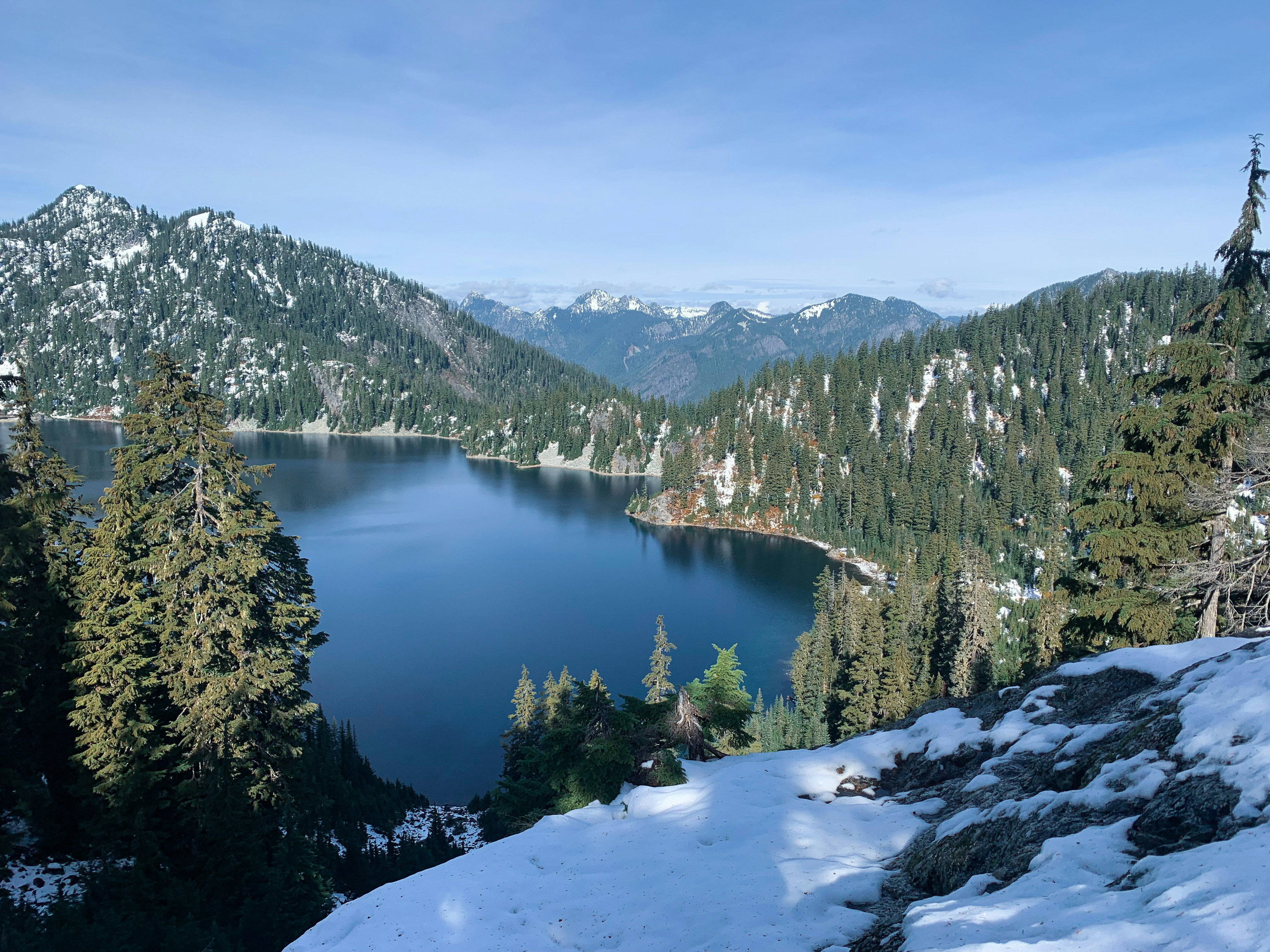 a lake surrounded by snow and trees