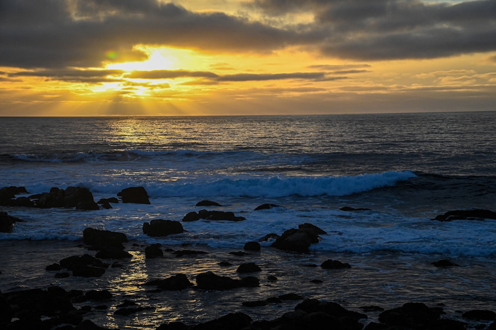 a rocky beach with a sunset