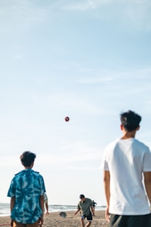 Group of friends playing volleyball on the beach, all wearing GoPlay Serious gear