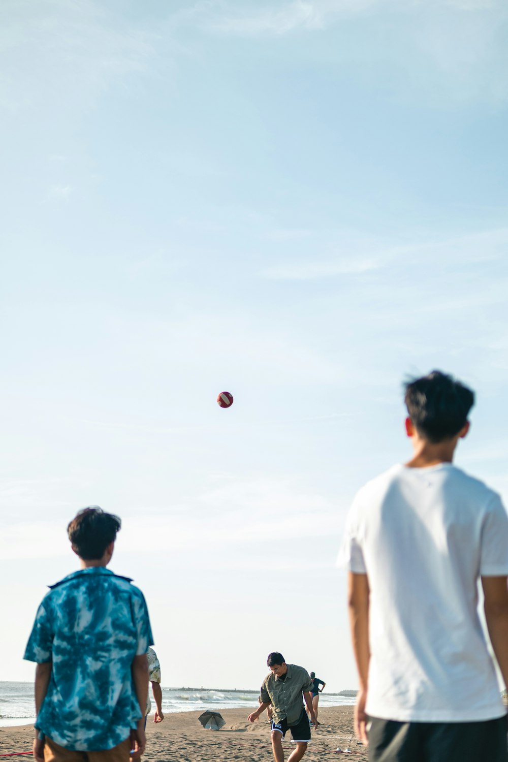 a group of people playing frisbee on a beach