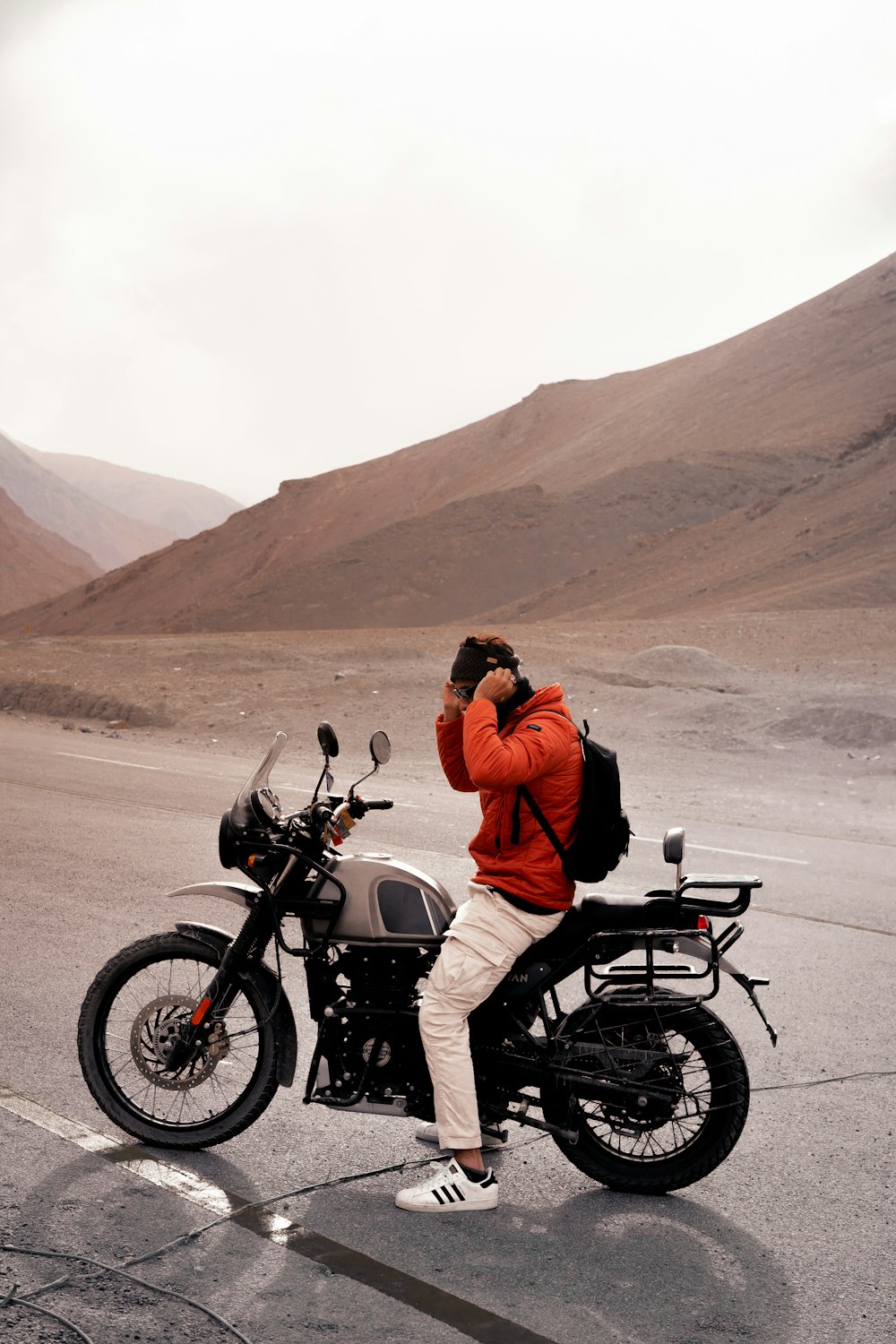 a man standing next to a motorcycle