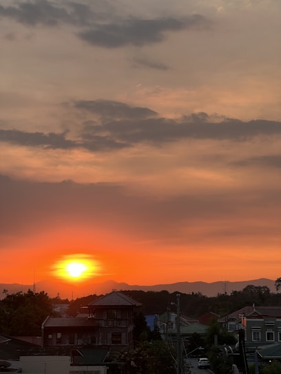 A vibrant sunset over a mountain village with colorful houses.