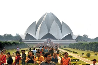 a large crowd of people in front of a large building with Lotus Temple in the background