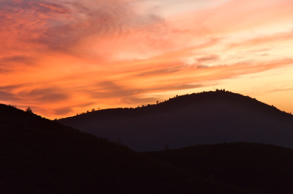 Una colina con una puesta de sol al fondo