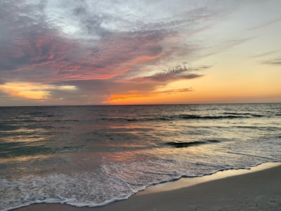 A serene beach resort setting with crystal-clear waters at sunset.