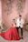 Elegant couple posing with a magazine-style photo booth backdrop in soft pink tones.