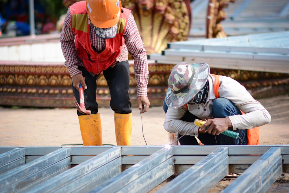Men wearing hard hats and working on a construction project photo – Free  Welding Image on Unsplash