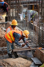 a few men in hardhats working on a construction site