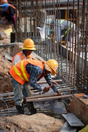 a few men in hardhats working on a construction site