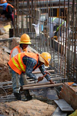 a few men in hardhats working on a construction site