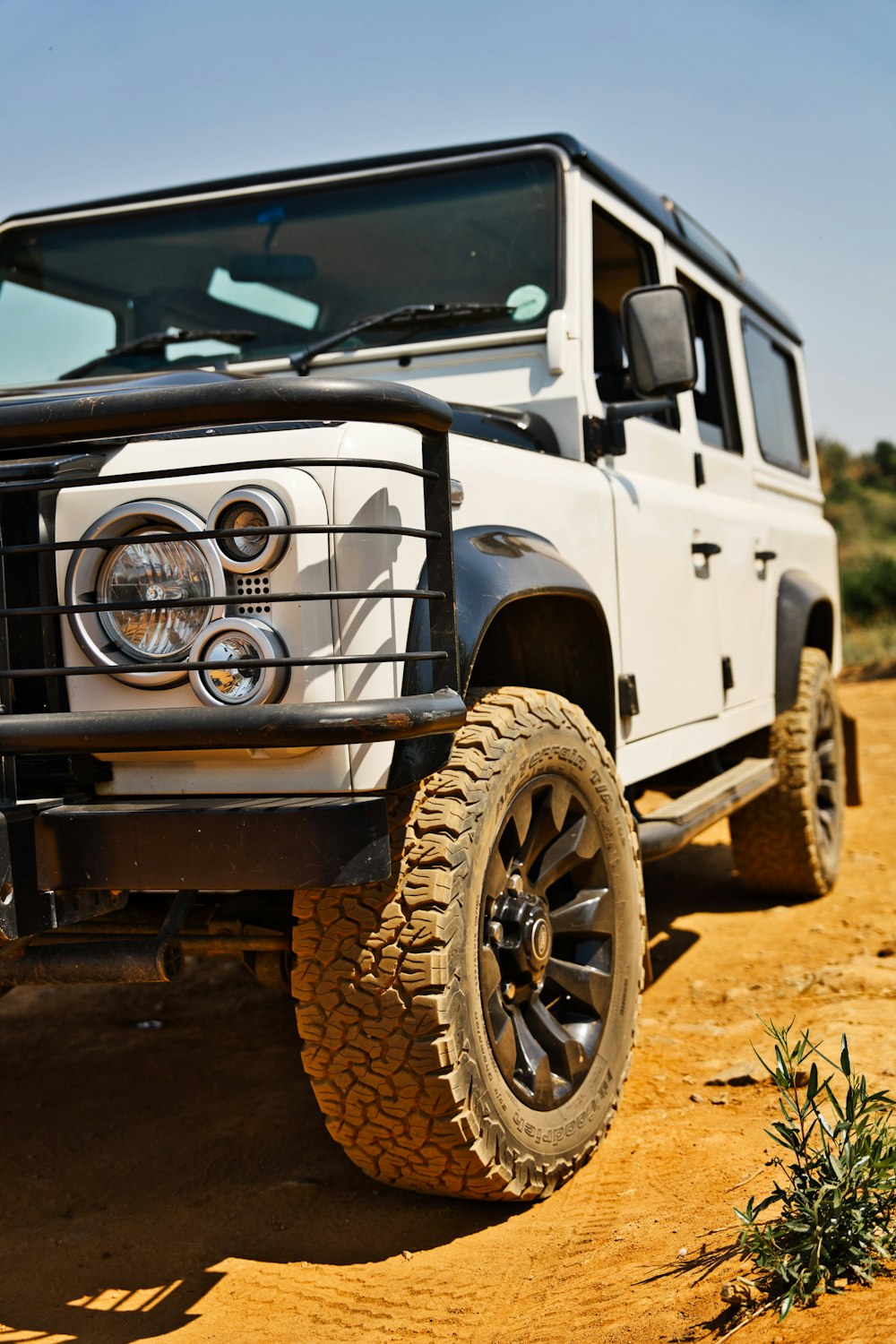 a white jeep parked on a dirt road