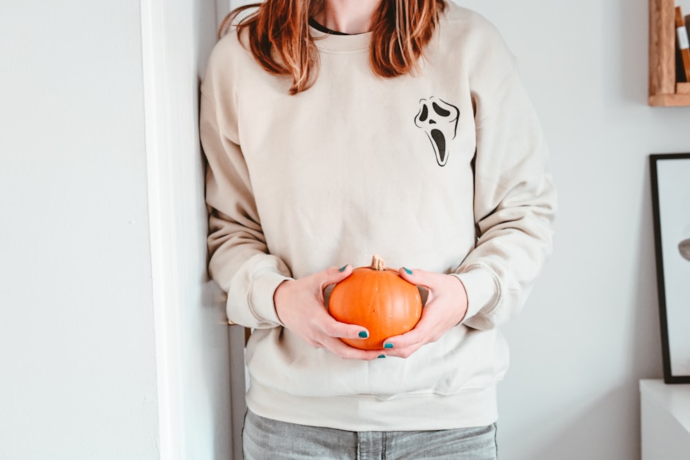 a person holding a pumpkin