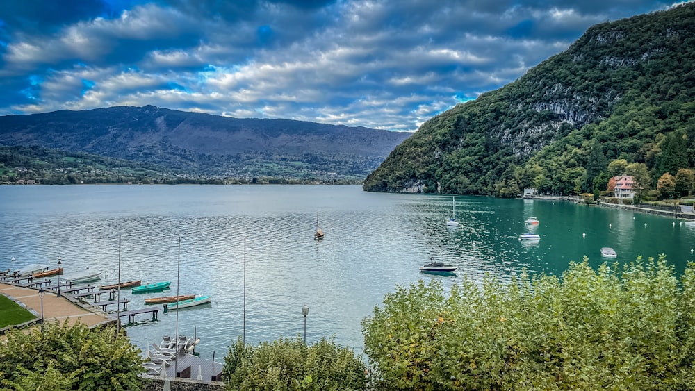 un plan d’eau avec des bateaux dedans et des montagnes à l’arrière