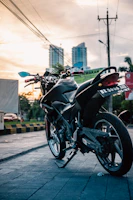 A sleek delivery motorbike speeding through an urban UAE landscape at sunset.
