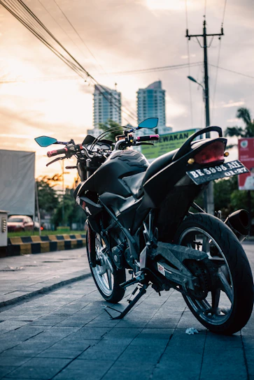 A sleek black sport motorcycle parked on a city street at dusk.