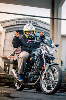 A motorcyclist happily signing insurance documents at a dealership counter.