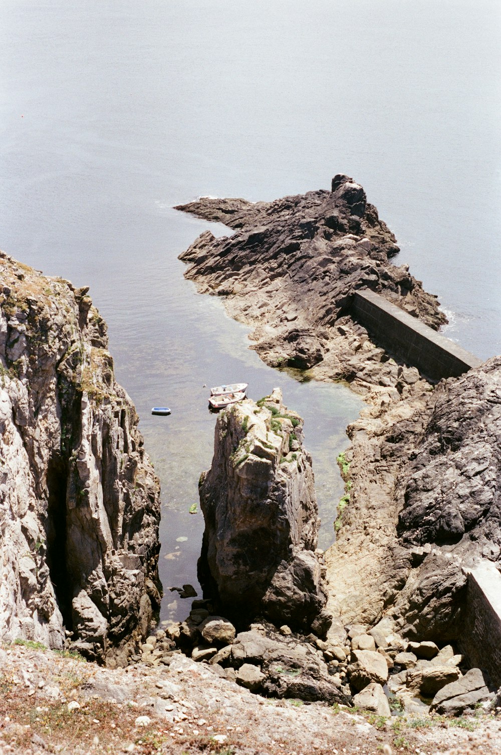 물 속에 보트가있는 바위 절벽