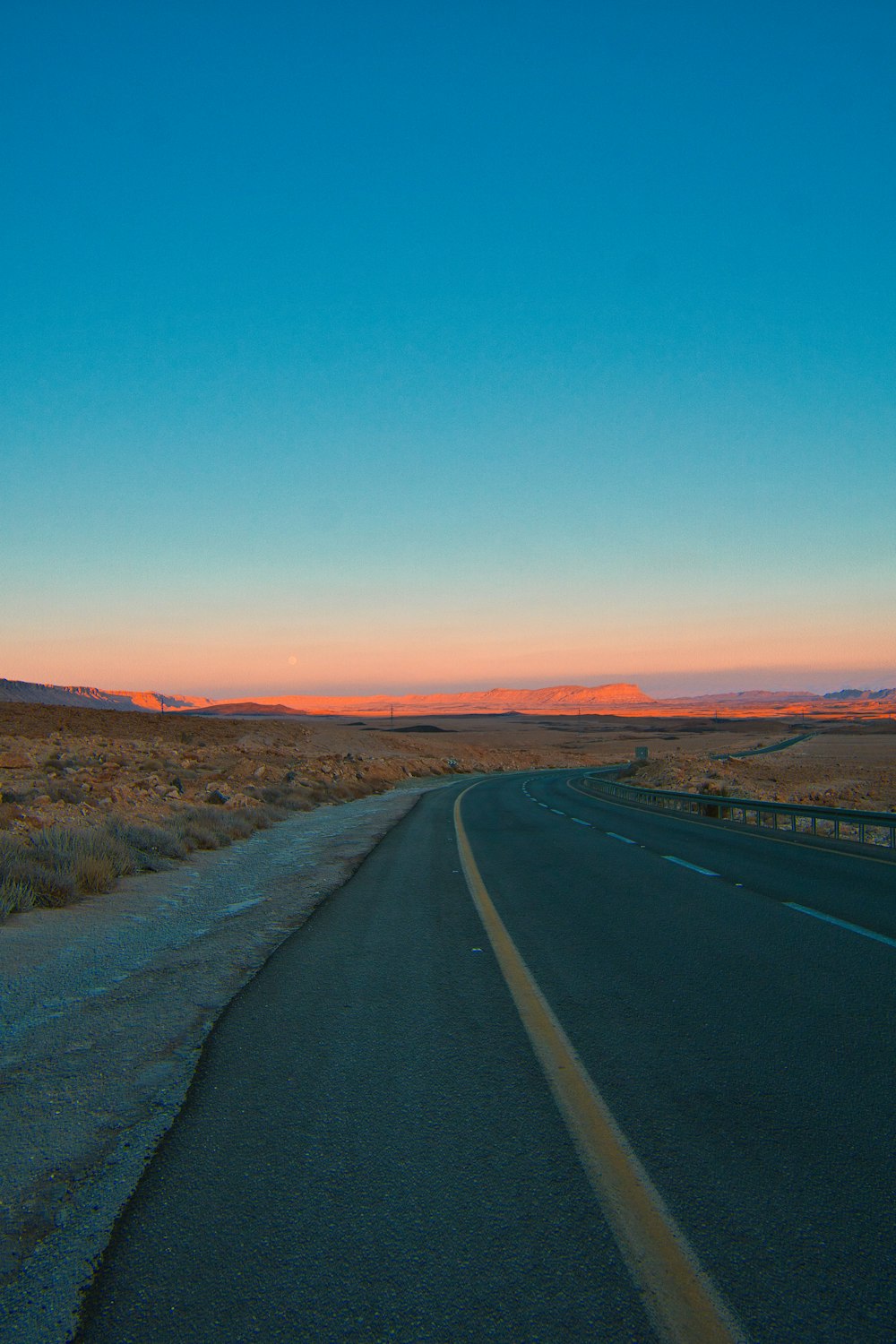 Una carretera con una puesta de sol al fondo