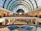 A bustling shopping center with various retail stores and ample parking space.