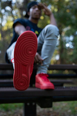 Soft-focus image of a woman sitting on a bench, showcasing crownface shoes in natural light.