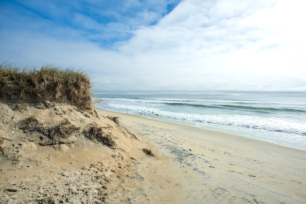 Ein Sandstrand mit Wellen, die darauf stürzen