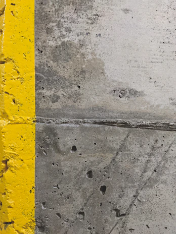 Close-up of a high-visibility yellow curb marking freshly painted by Flexline Coatings.