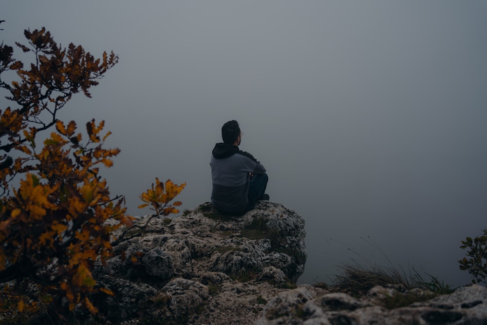 a person sitting on a rock