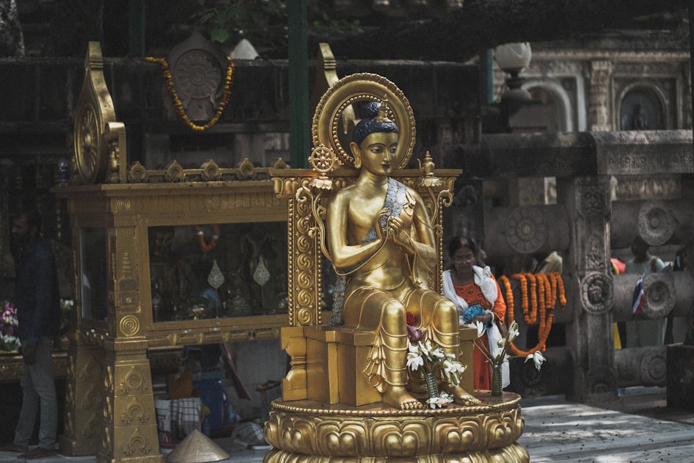 a person sitting on a gold statue