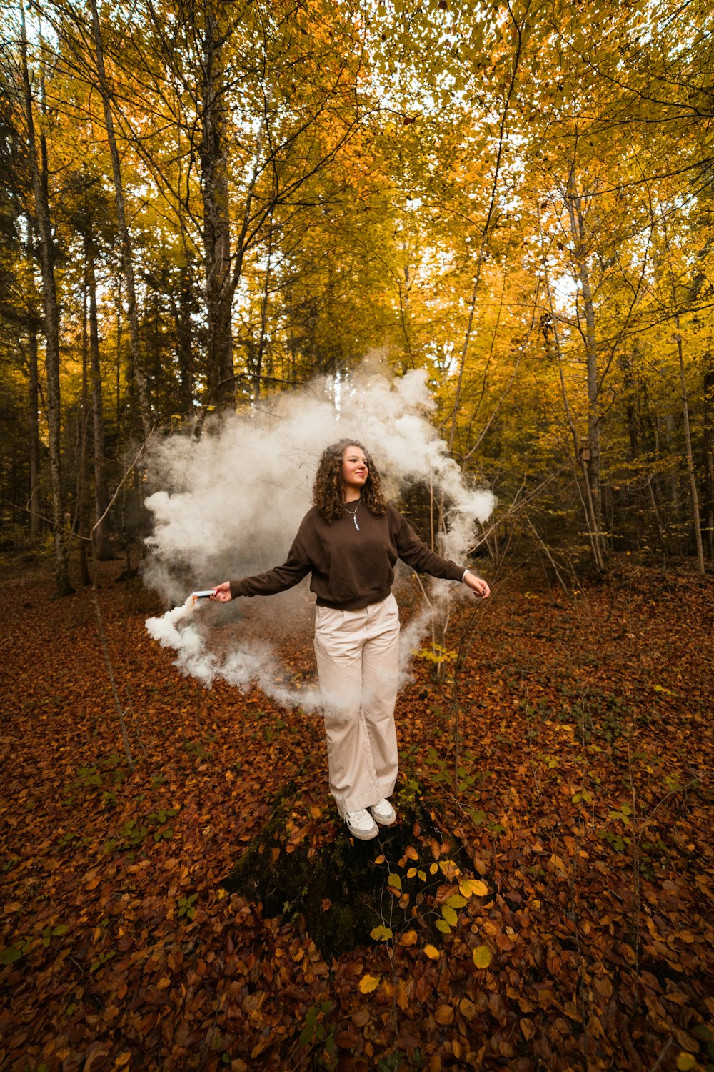 Un hombre parado en un bosque con una nube de humo blanco