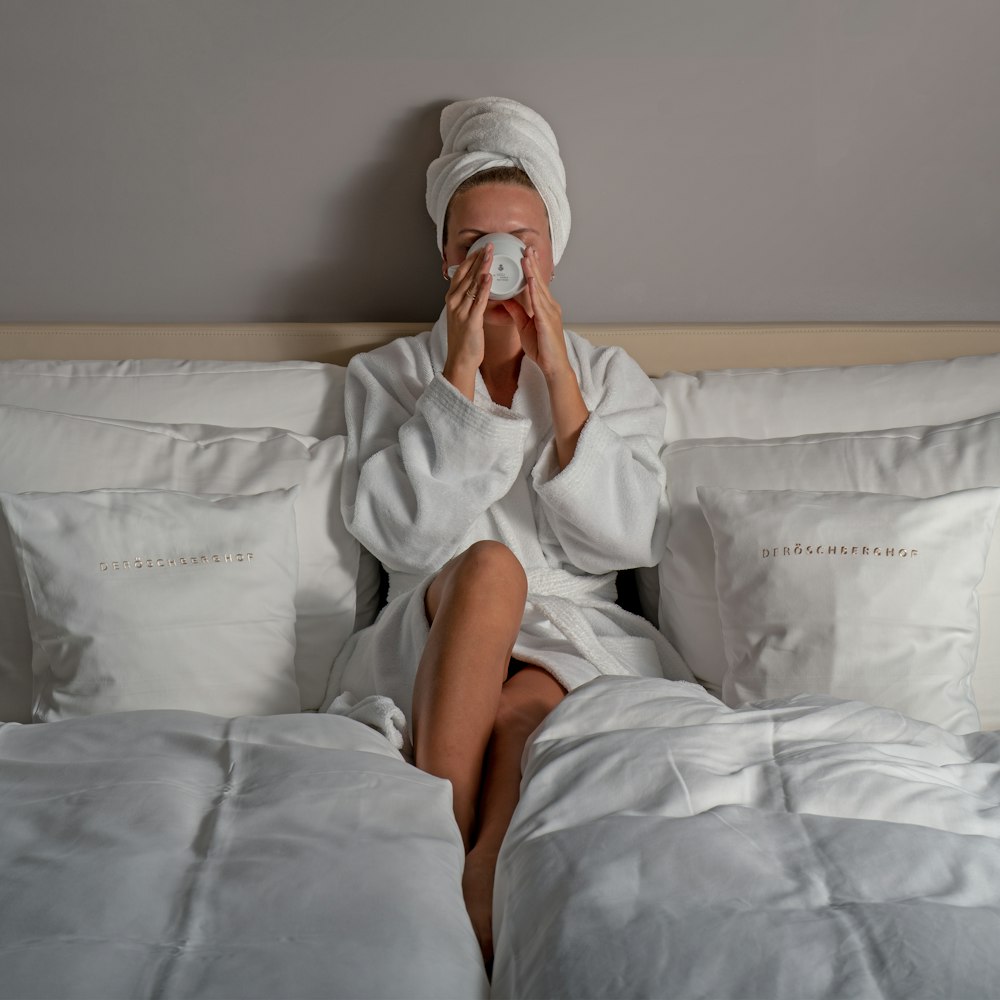 a person sitting on a bed holding a camera