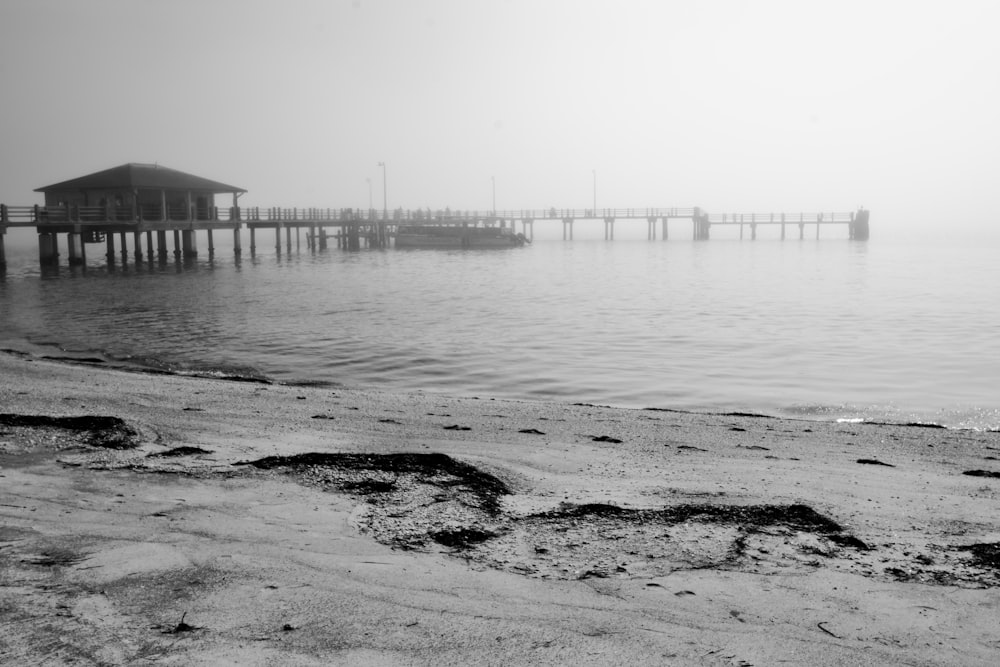 a beach with a pier in the distance