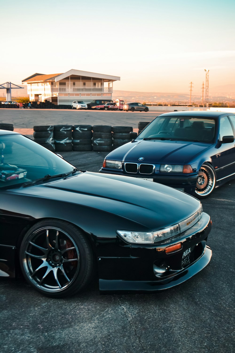 a couple of cars parked next to each other with a building in the background