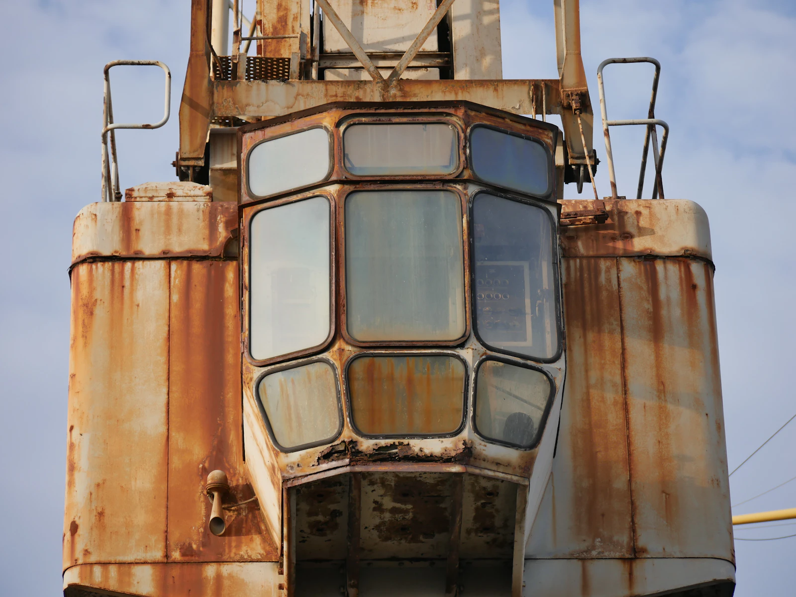 Two large weathered shipping containers seen from ground level