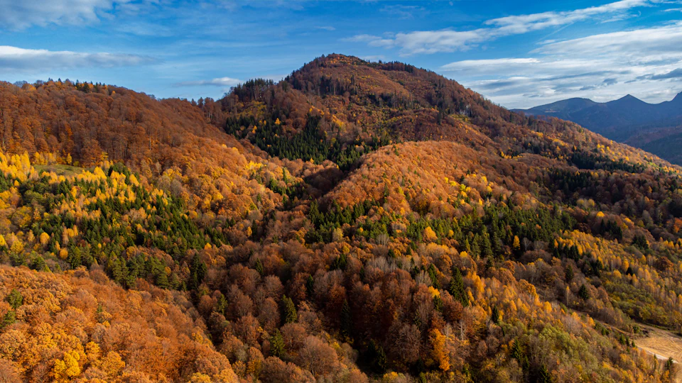 Mountainous landscape viewed from above with brown and orange mountains against blue sky