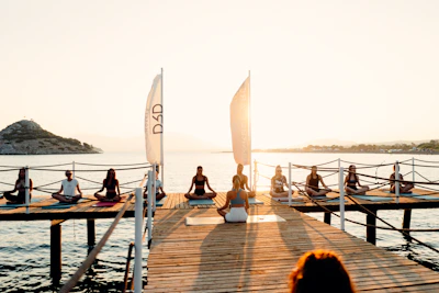 a group of people sitting on a dock by the water