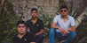 a group of men sitting on a rock wall