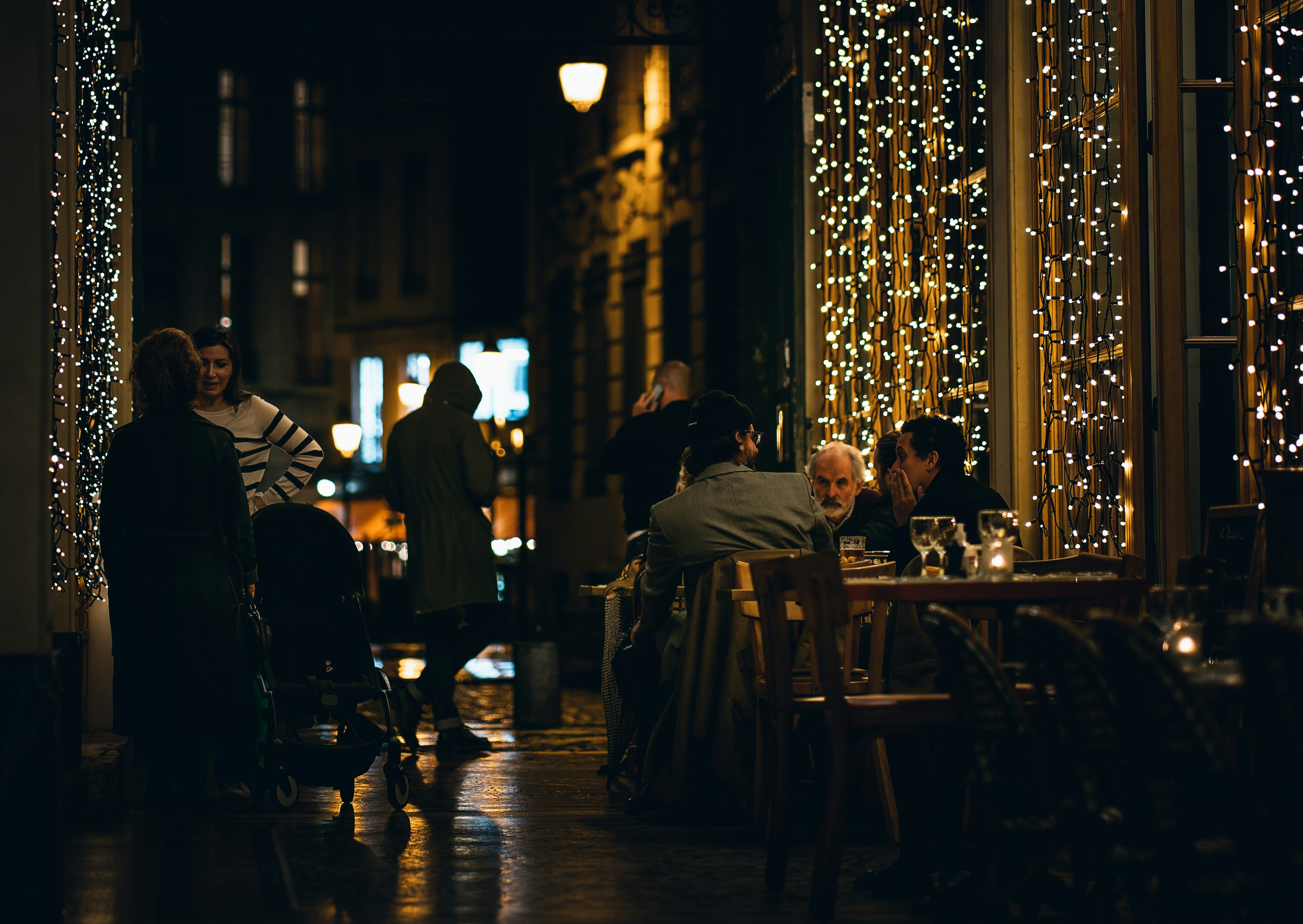 A cozy restaurant interior with soft lighting, a small stage where a jazz musician plays a saxophone, and diners enjoying their meals at tables