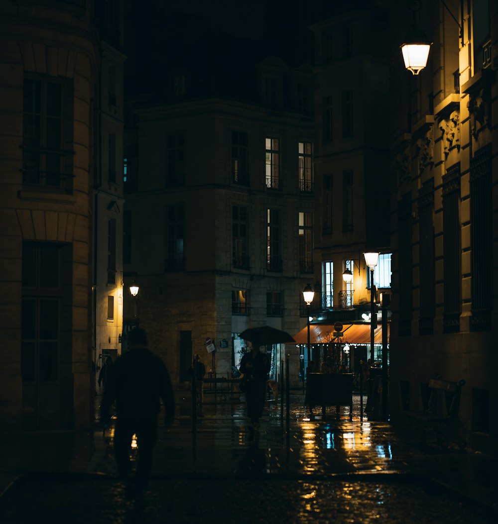 people walking down a street with umbrellas