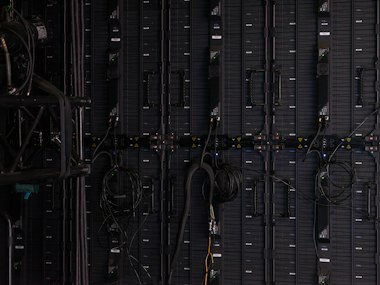 Photo of the back of an AV equipment rack with cabling, texted in from the field