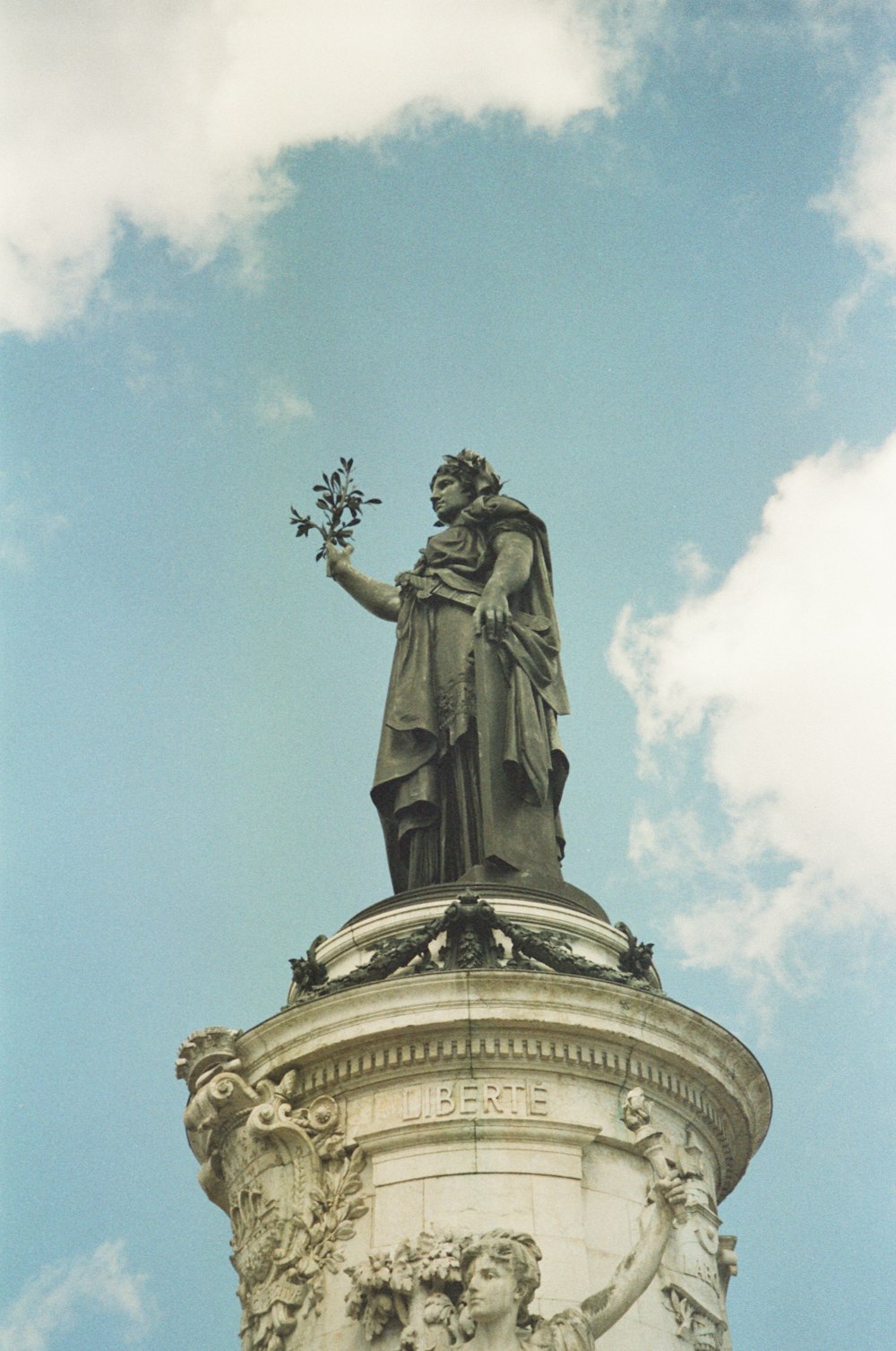 uma estátua de uma pessoa segurando um bastão