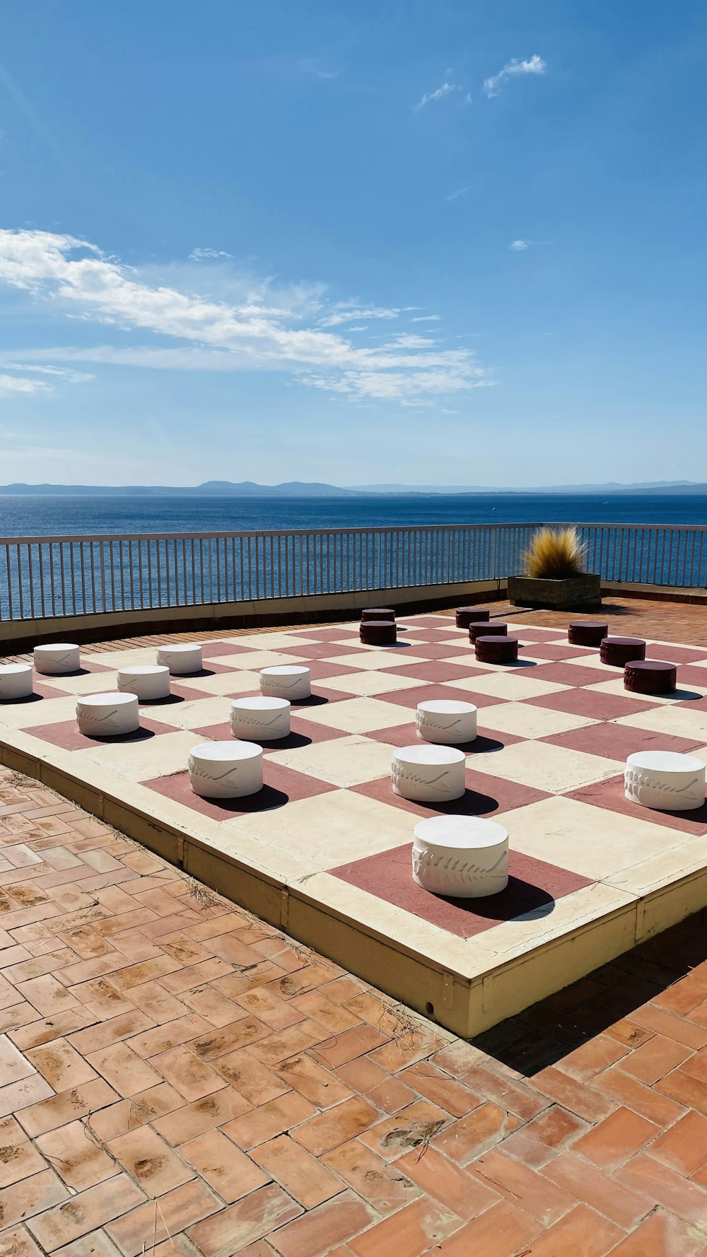 a group of white pots on a brick surface by a body of water