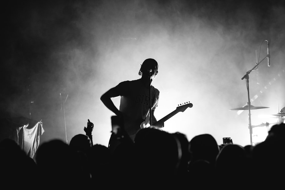 a man on a stage with a microphone and a crowd of people