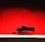 Image of a grand piano on stage with soft spotlight