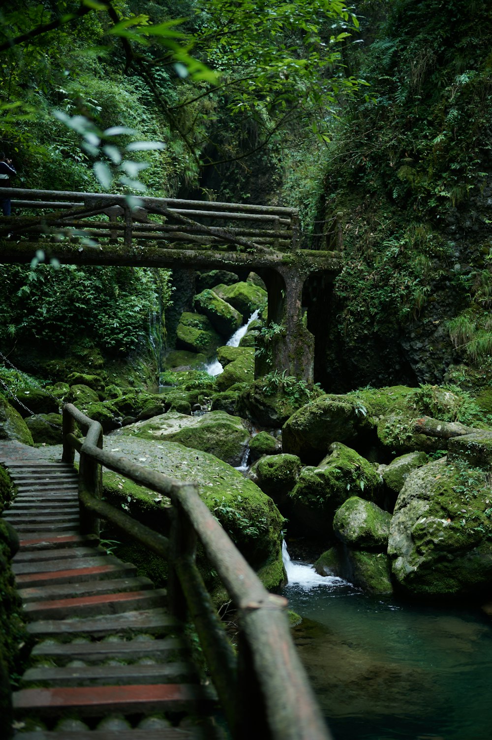 a wooden bridge over a stream