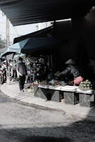 A vibrant outdoor market scene in Vietnam with caps displayed under natural sunlight.