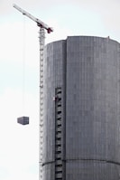 Crane lifting materials high above a building under construction.