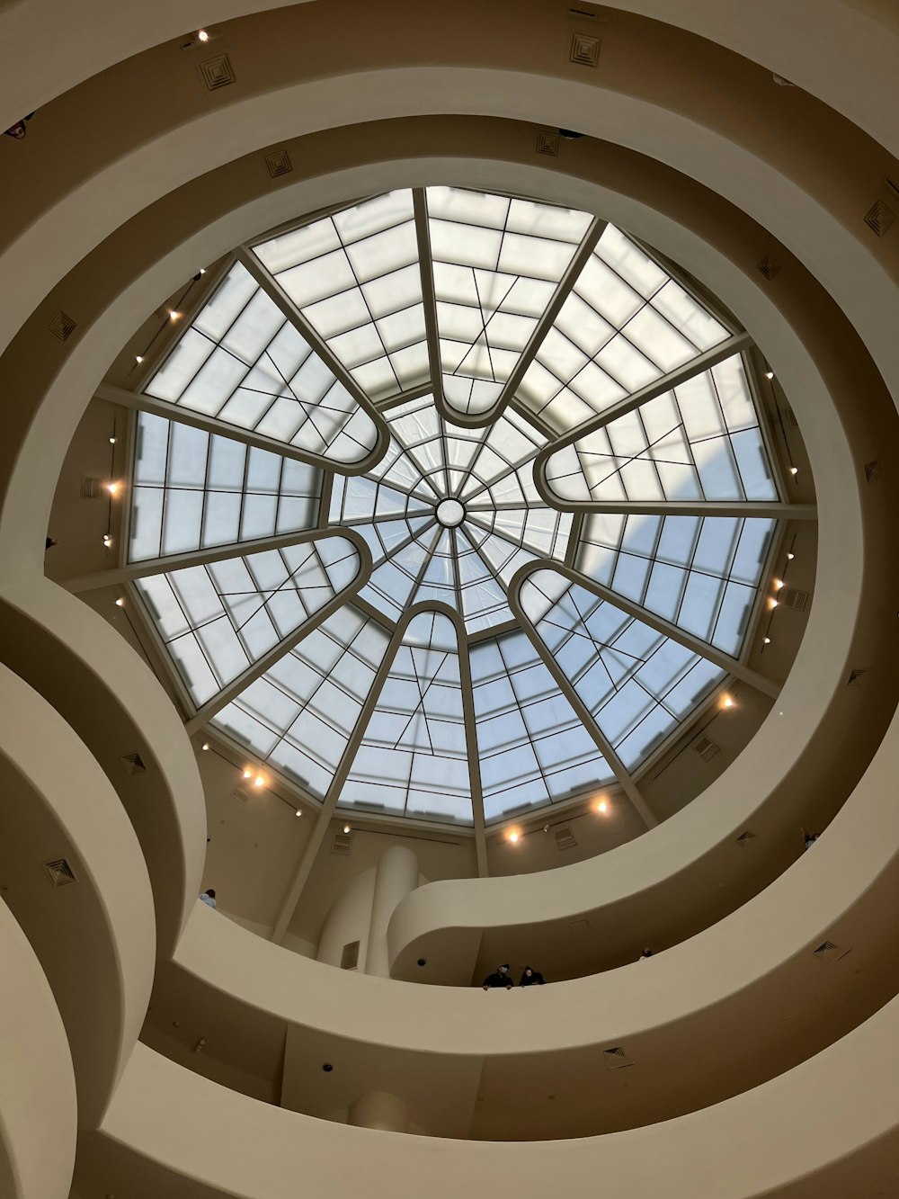 a spiral staircase with a glass ceiling with Solomon R. Guggenheim Museum in the background
