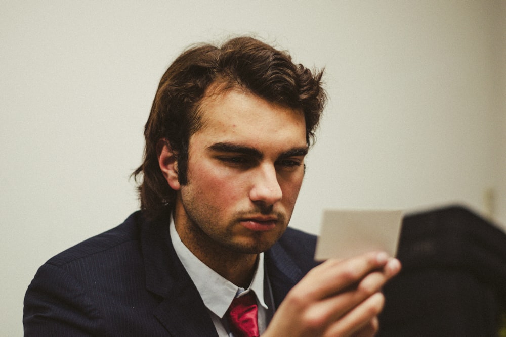 a man in a suit looking at a tablet