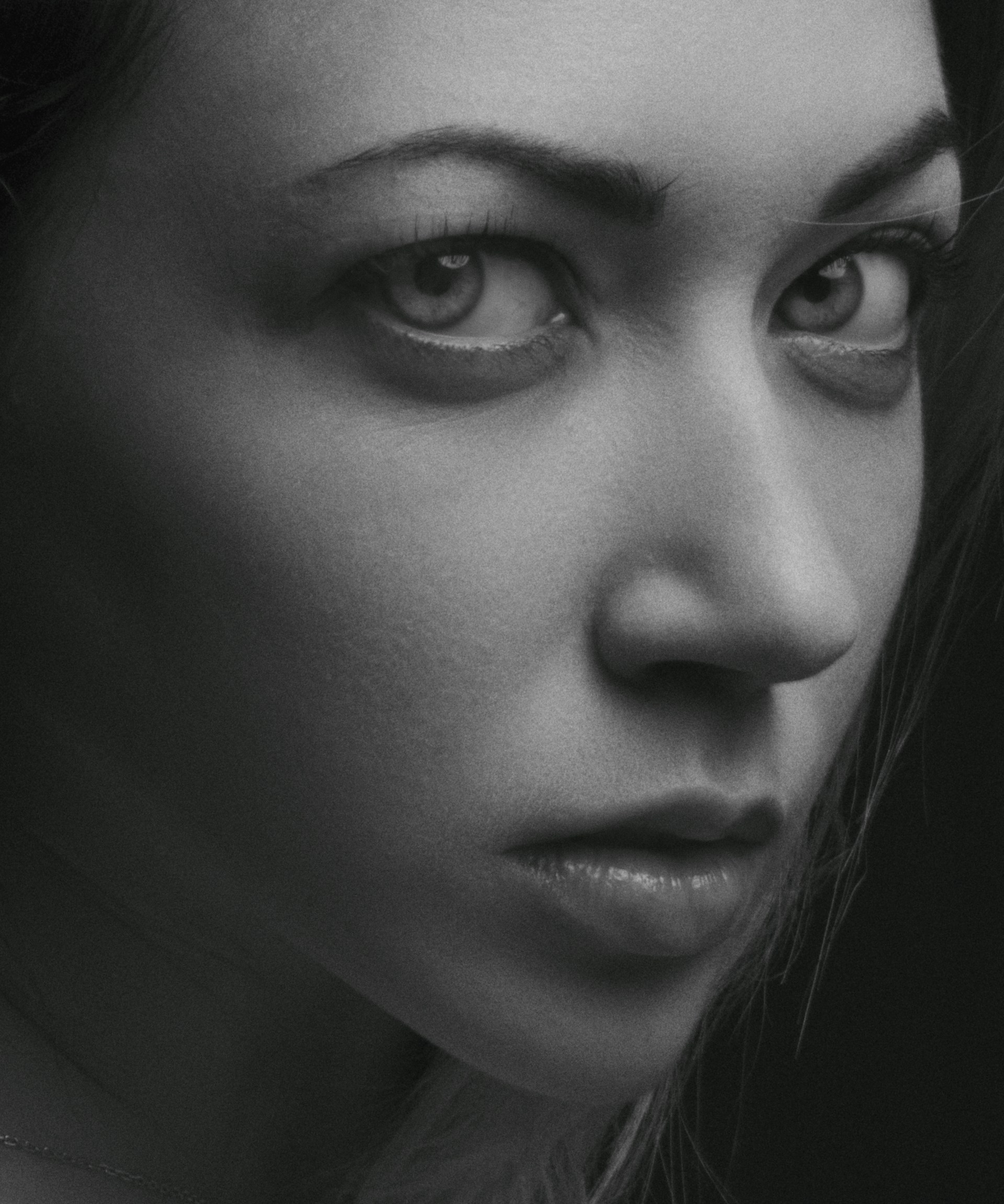 A close-up shot of an intricately framed black-and-white portrait, capturing deep emotion in the subject's eyes.